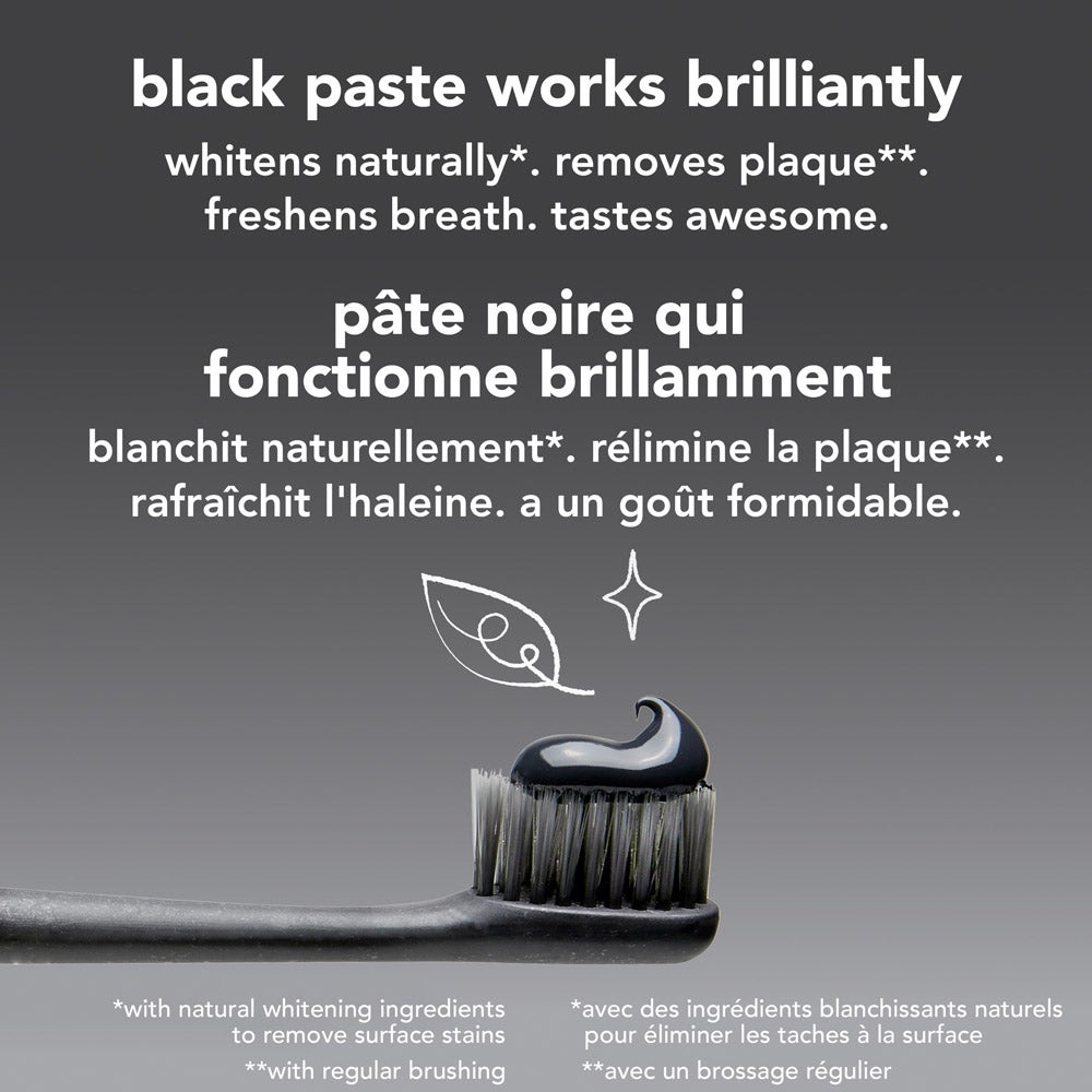 A close-up of a toothbrush with black bristles holding a swirl of black toothpaste, set against a light grey background. Above the toothbrush, text reads: &quot;black paste works brilliantly – whitens naturally*, removes plaque**, freshens breath, tastes awesome.&quot; Fine print at the bottom provides additional information about whitening and plaque removal.