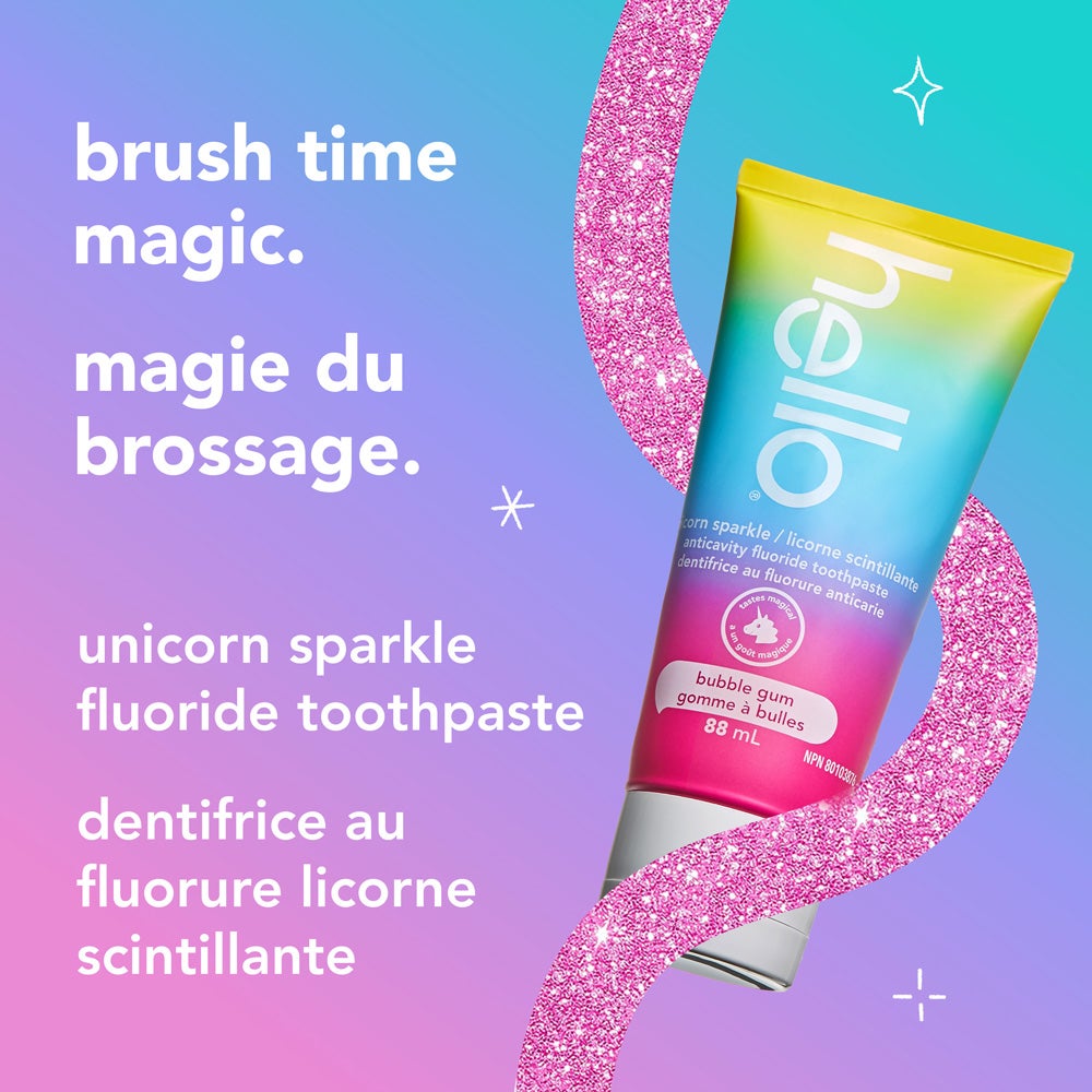 A tube of hello unicorn sparkle bubble gum fluoride toothpaste is displayed on a sparkly pink curved border with a colorful pastel background. The text reads, "brush time magic. unicorn sparkle fluoride toothpaste."