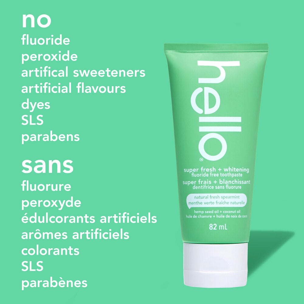 A green tube of hello super fresh + whitening fluoride free toothpaste stands upright on a solid green background. On the left, a list of ingredients not in the toothpaste reads: "no fluoride, peroxide, artificial sweeteners, artificial flavours, dyes, SLS, parabens
