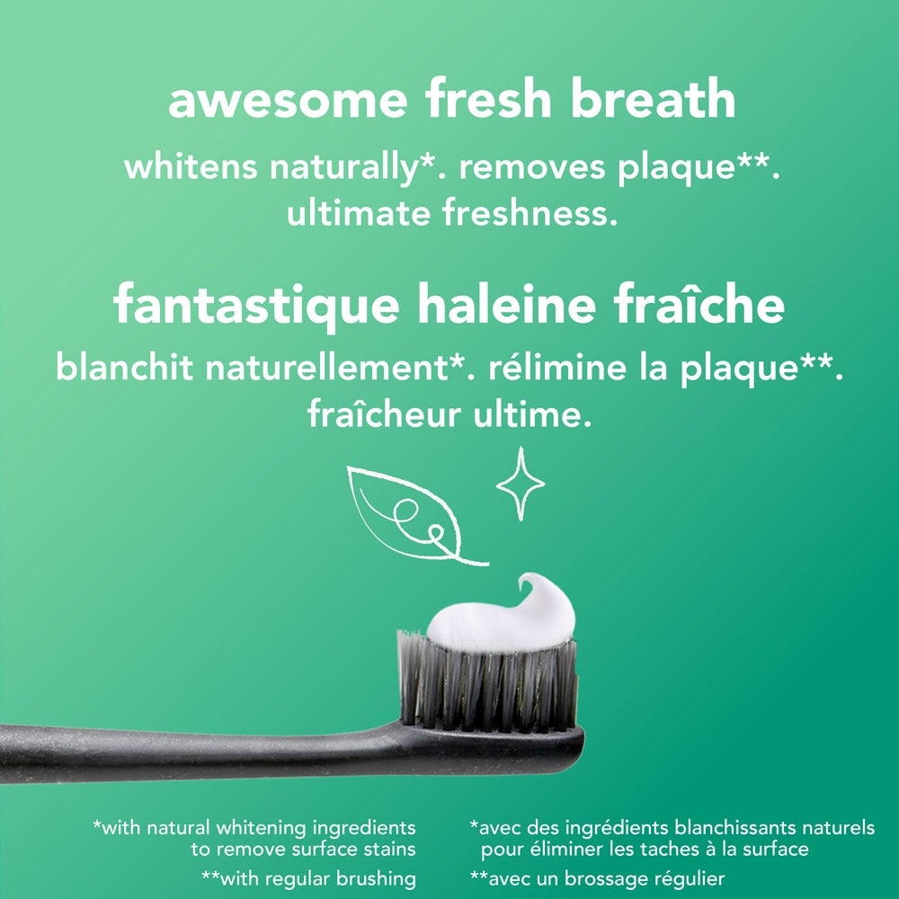 A close-up of a toothbrush with black bristles holding a swirl of white toothpaste, set against a green background. Above the toothbrush, the text reads: "awesome fresh breath – whitens naturally*, removes plaque**, ultimate freshness." Fine print at the bottom provides additional information about whitening and plaque removal.